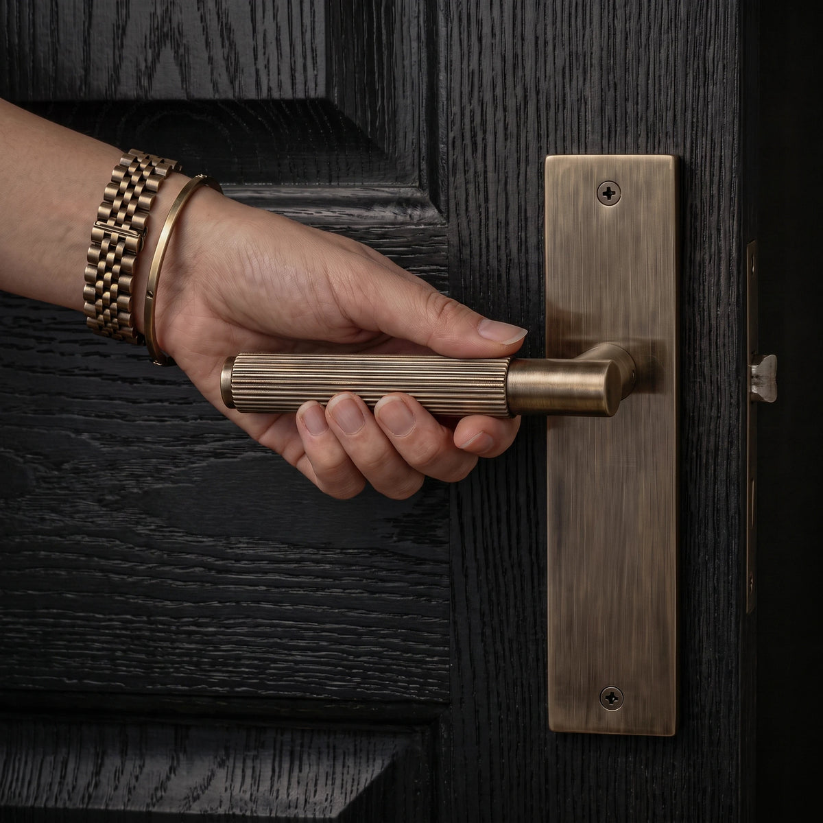 Hera Antique Brass Passage Door Handles on Backplate – held in hand to show the size and finish