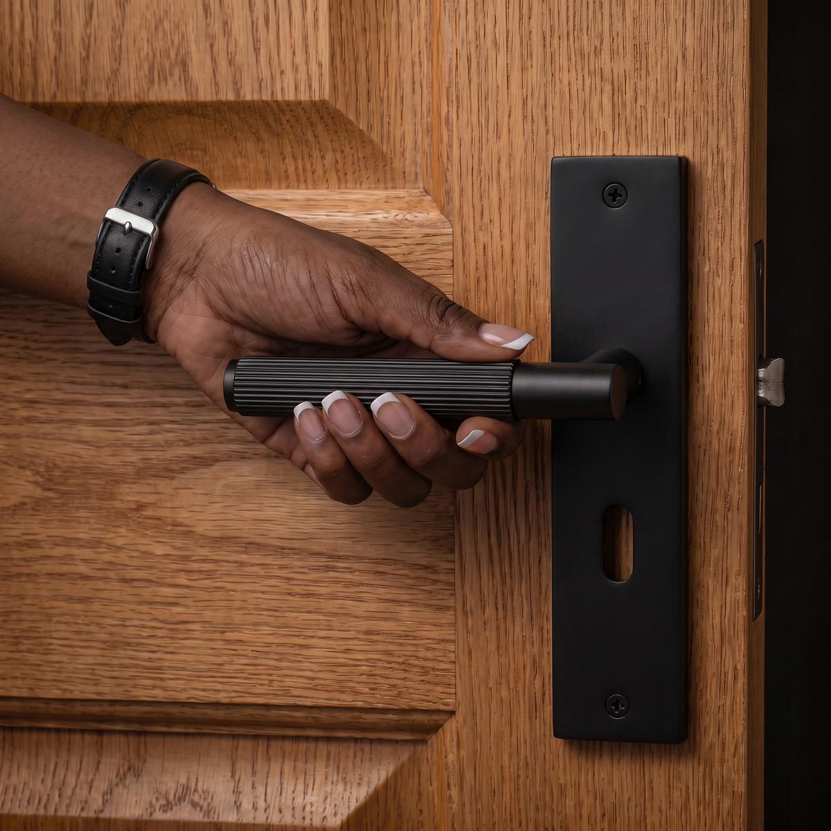 Hera Matt Black Privacy Door Lever Handles on Backplate – held in hand to show the size and finish