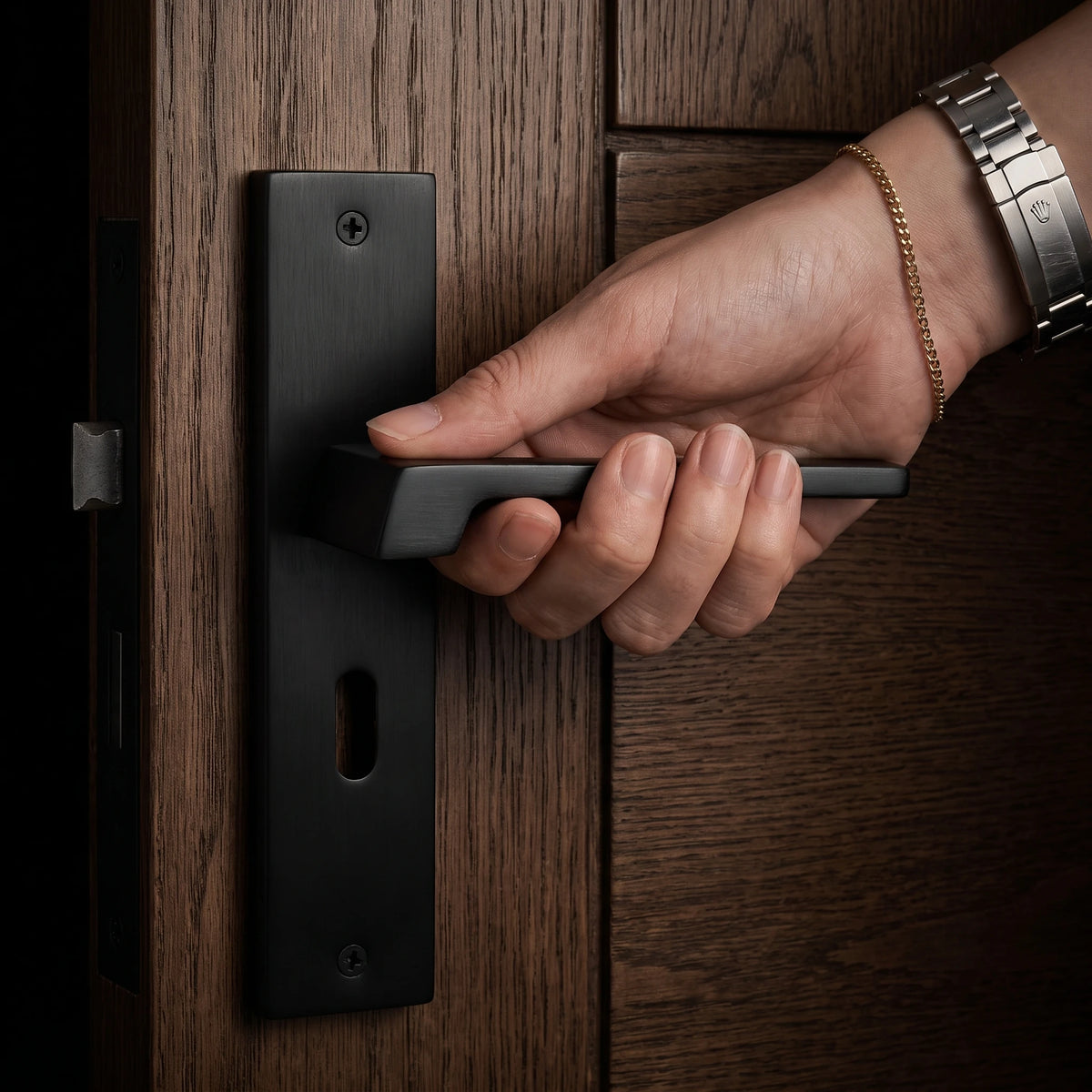 Spectra Matt Black Door Lever Handles on Backplate – held in hand to show the size and finish