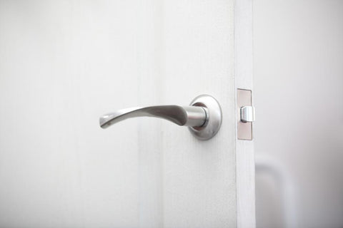 Silver door knob on a white door