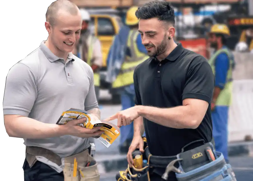 Two men in polo shirts examining construction or work documents together.